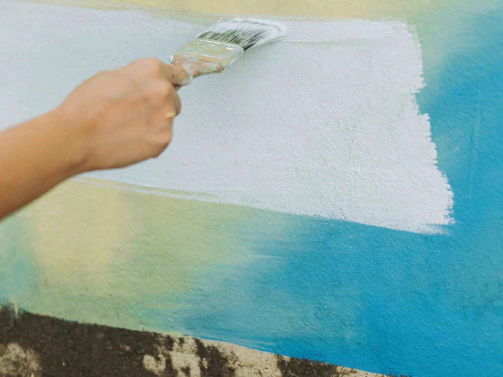 Trincha a pintar uma parede de azul