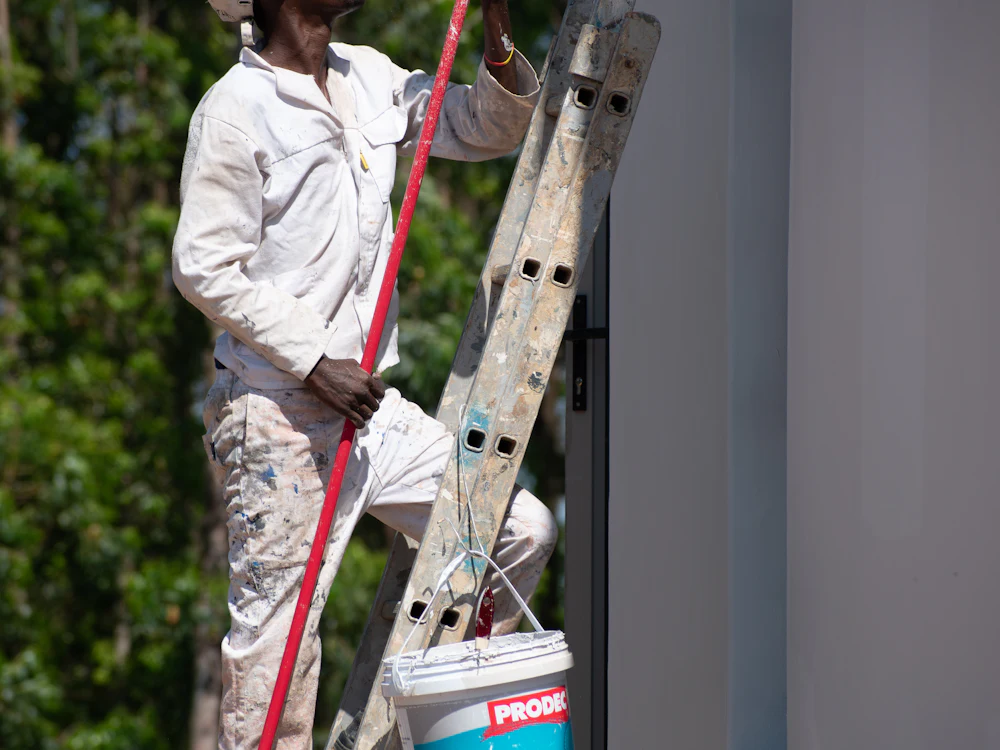 Pintor numa escada a pintar a parede