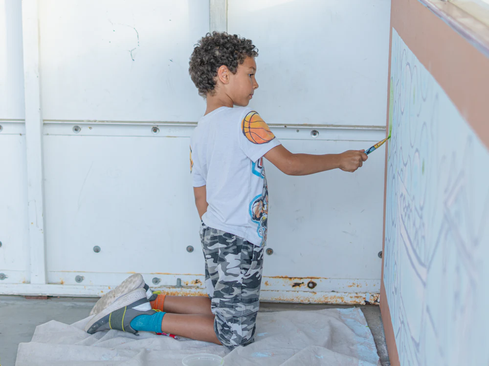 Menino a pintar a parede do quarto